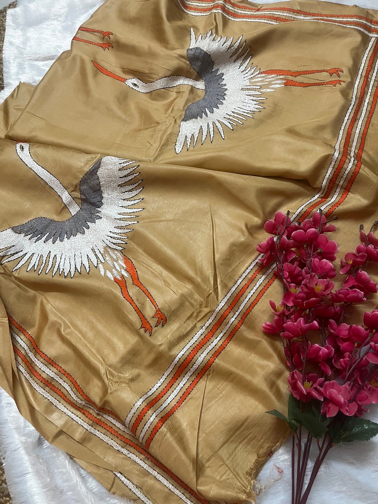 Close-up of handcrafted kantha stitch crane embroidery on beige handwoven silk fabric