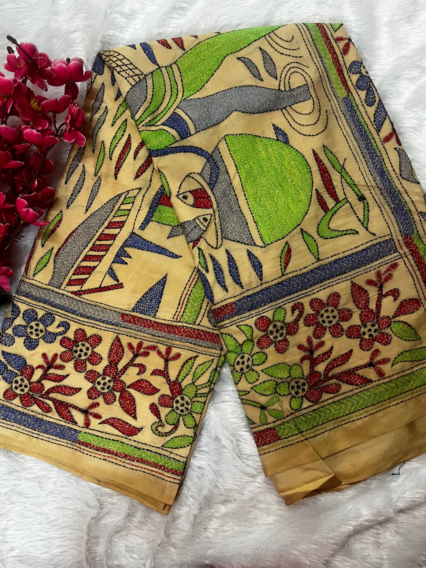 Close-up of human motif kantha embroidery on beige Bangalore Silk fabric