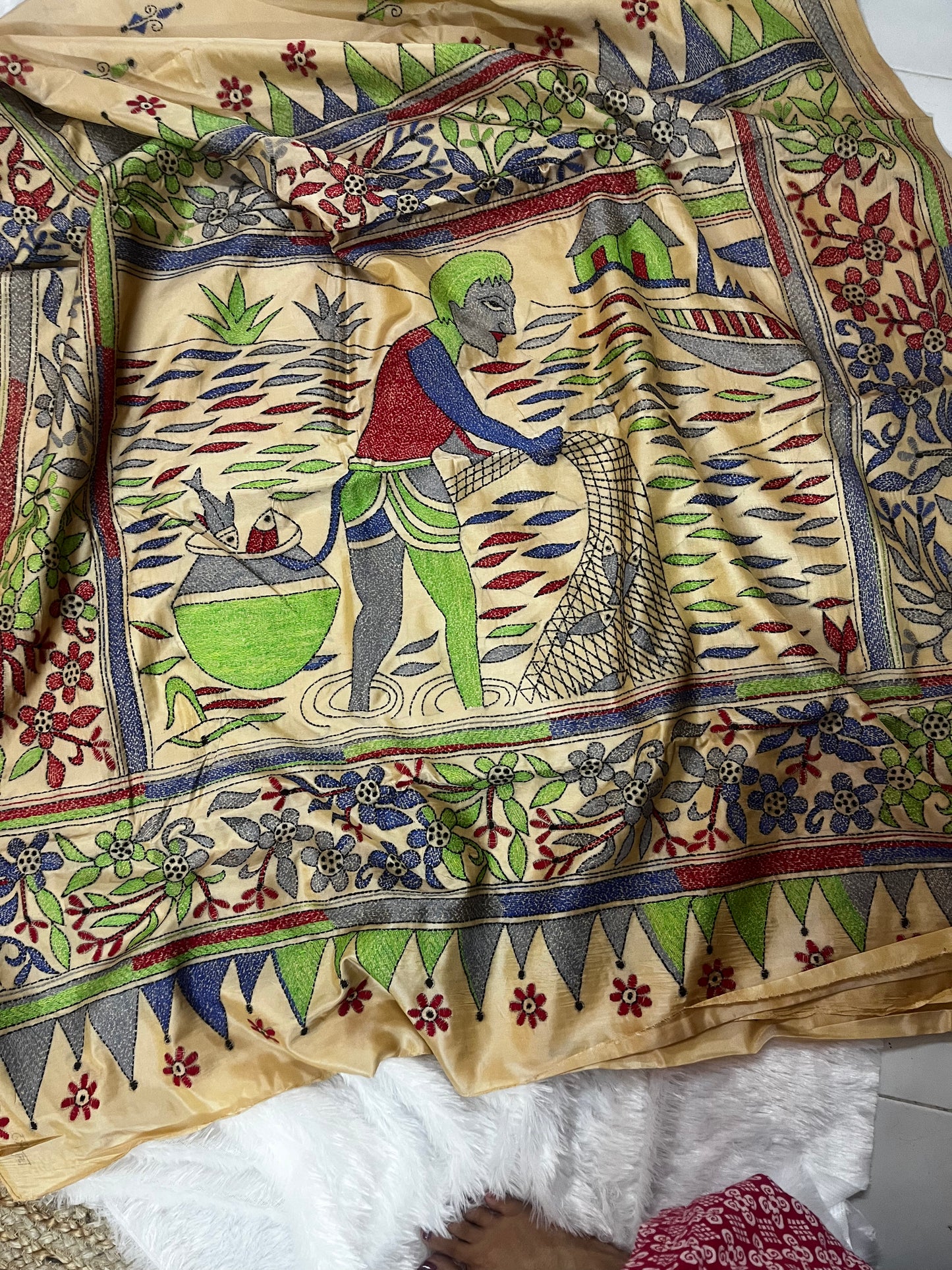 Close-up of human motif kantha embroidery on beige Bangalore Silk fabric