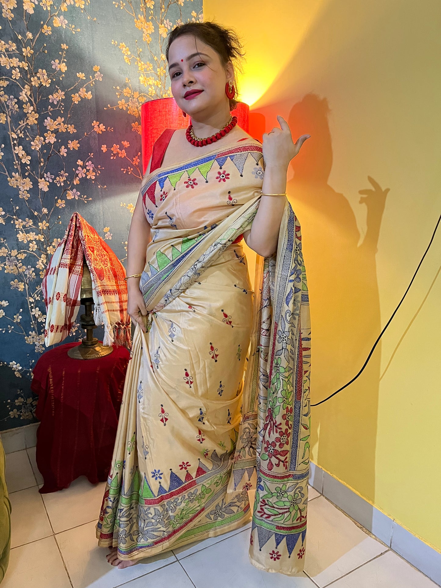 Model showcasing beige human motif saree in traditional styling