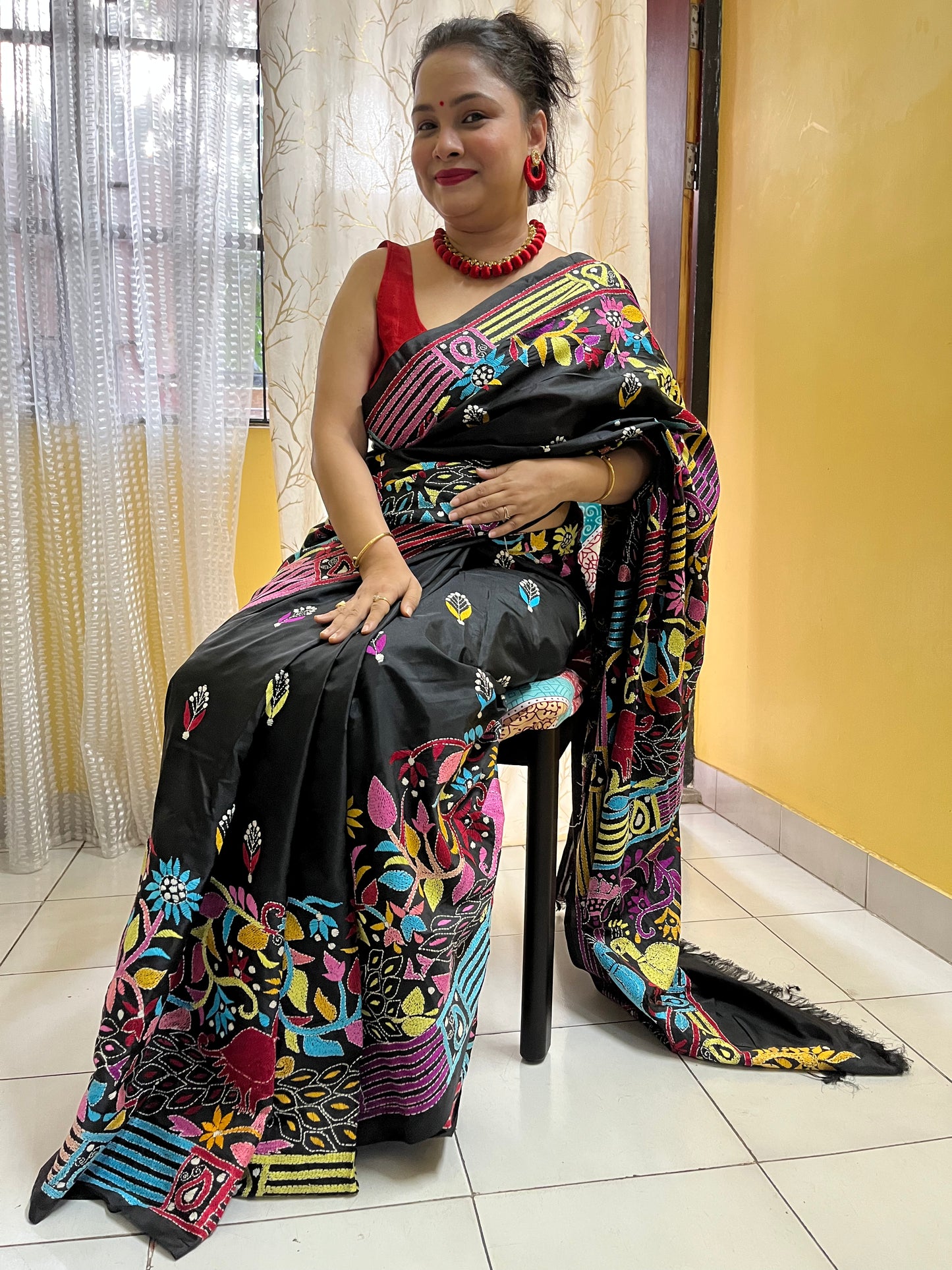 Model wearing black peacock motif saree showcasing traditional Indian styling