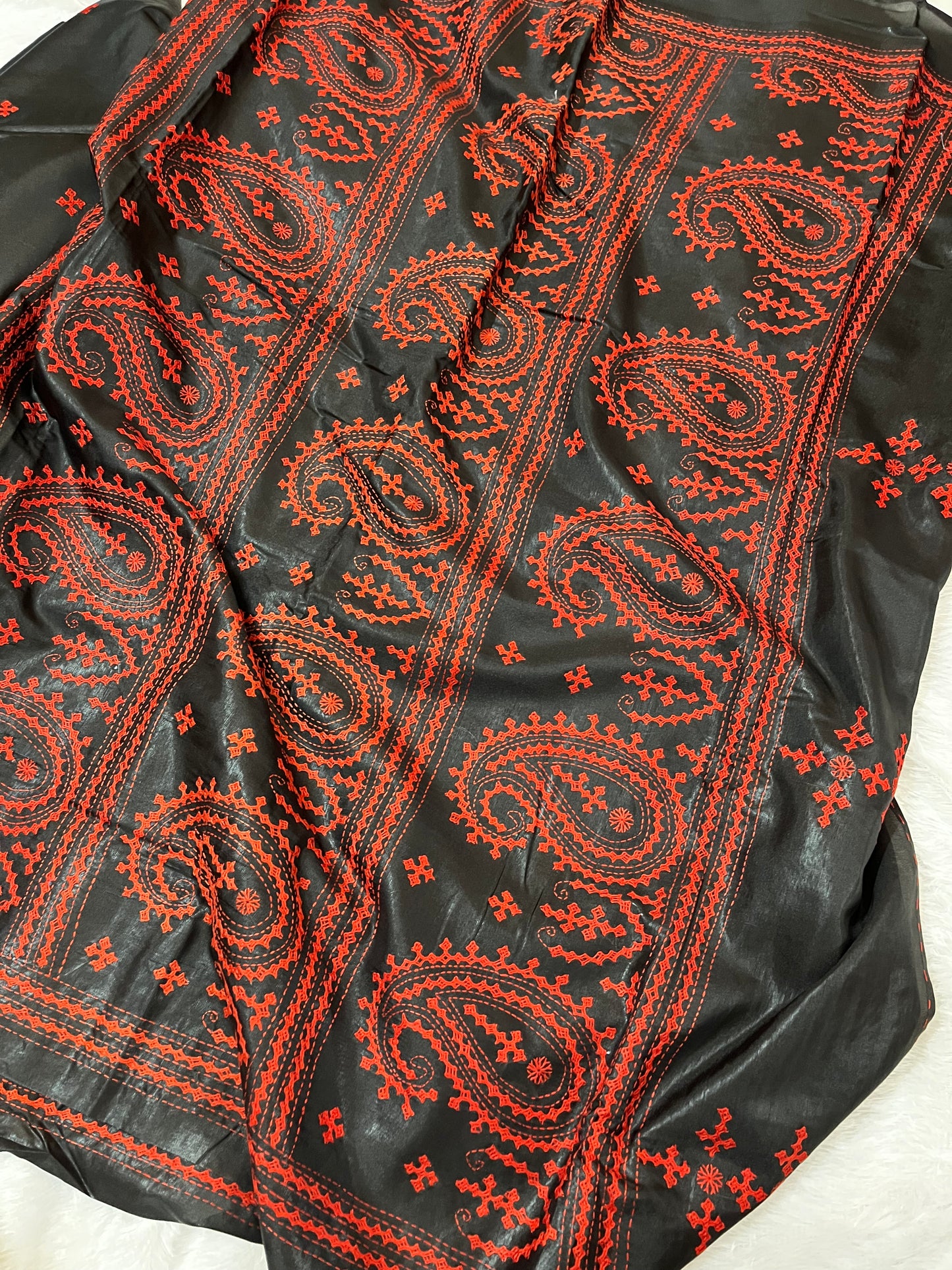 Close-up of red paisley motif Kantha embroidery on black Bangalore silk handwoven fabric