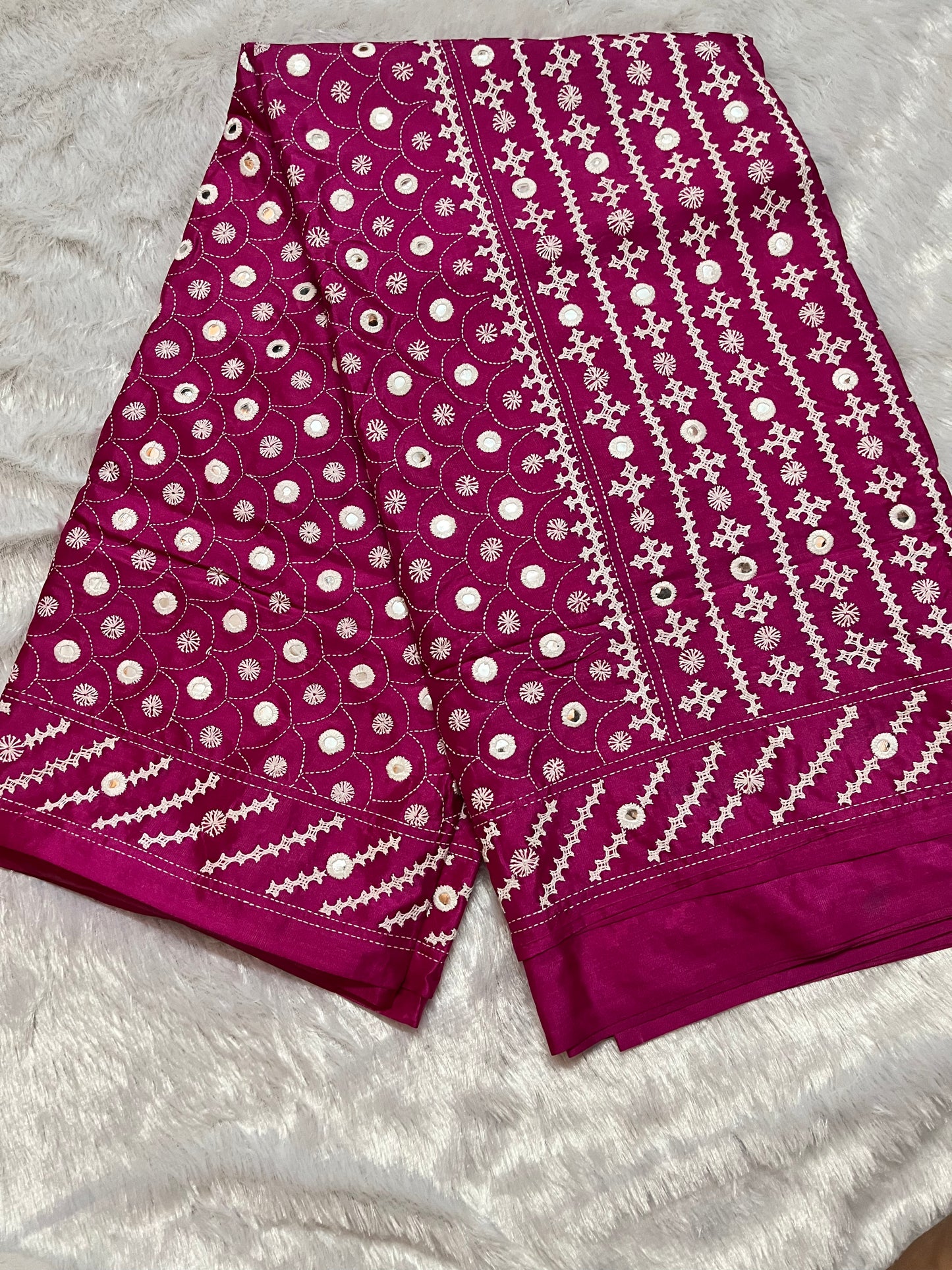 Close-up of geometric patterns and floral motifs with mirror work on deep burgundy Bangalore silk fabric