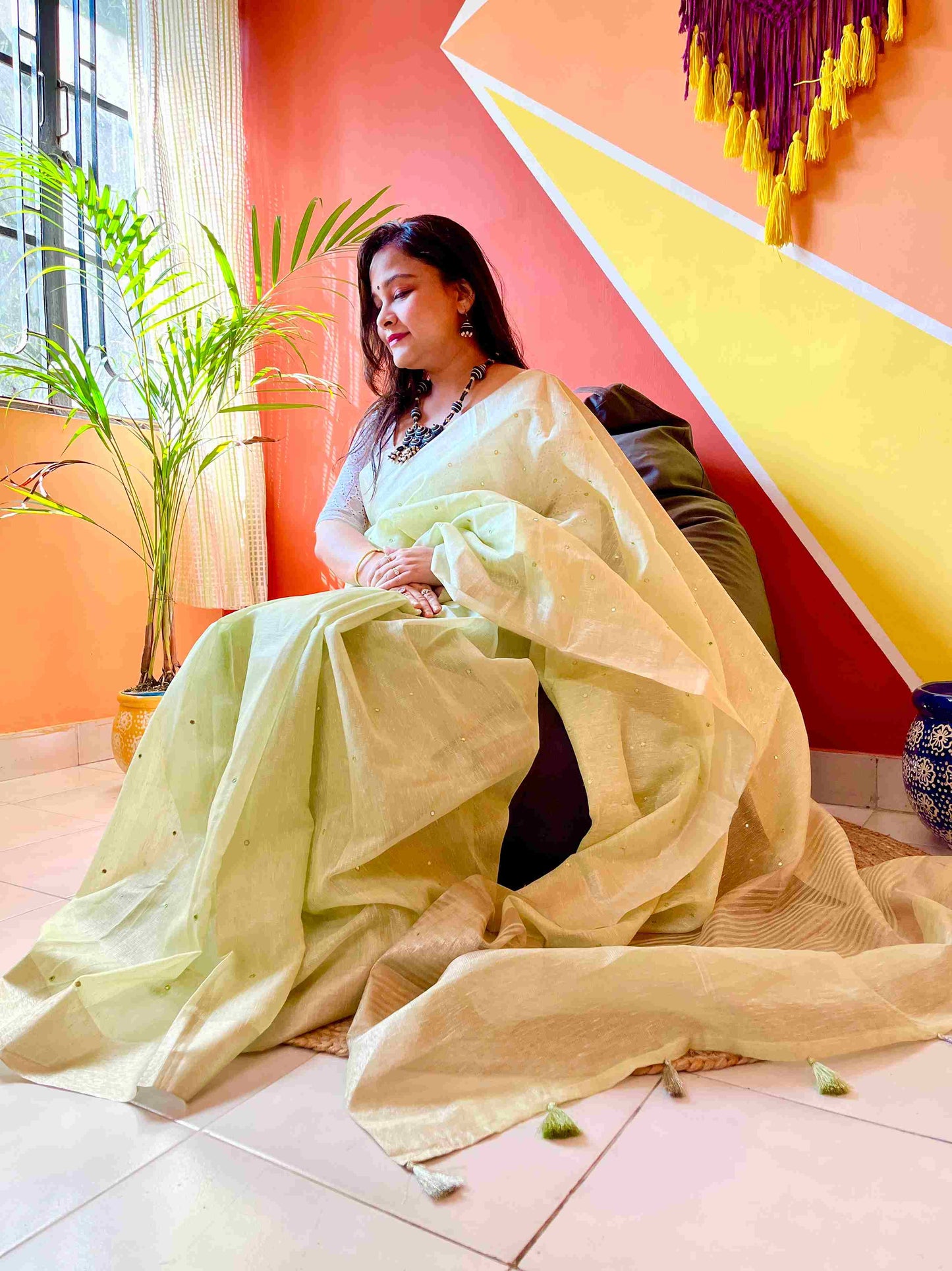 Graceful woman in Pista Green tissue saree showcasing Desi Aadat’s handwoven design