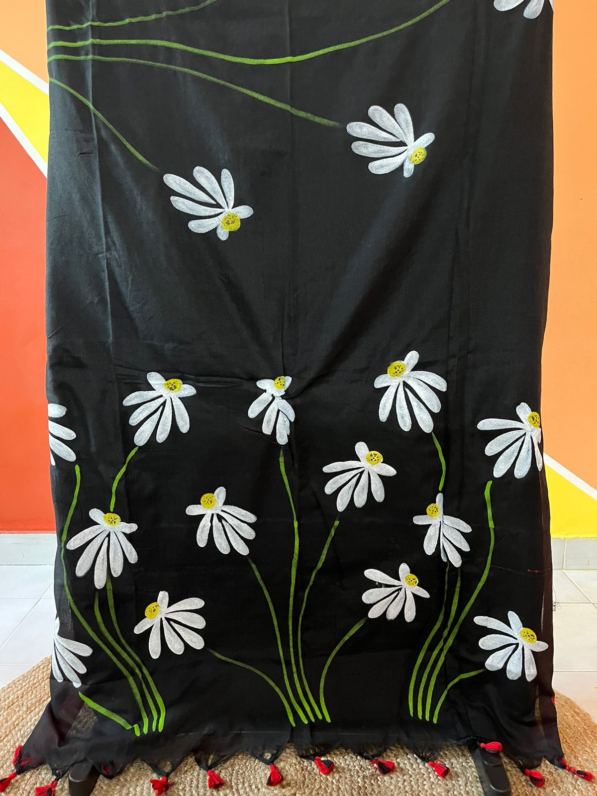 A woman draped in a black mul mul cotton saree, showcasing stunning hand-painted floral designs.