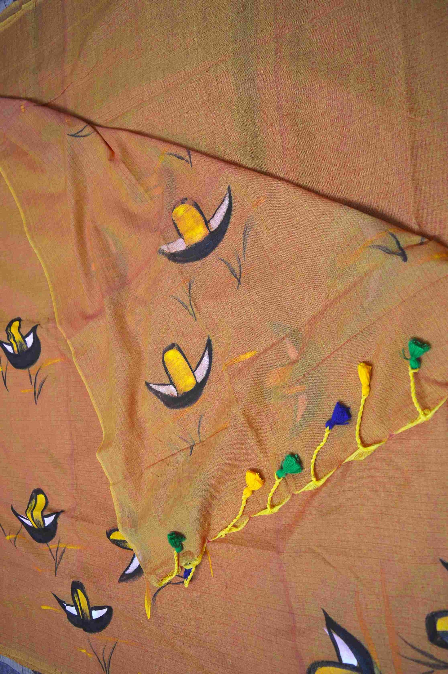 A woman wearing a soft mul mul cotton saree with exquisite hand-painted boat motifs.