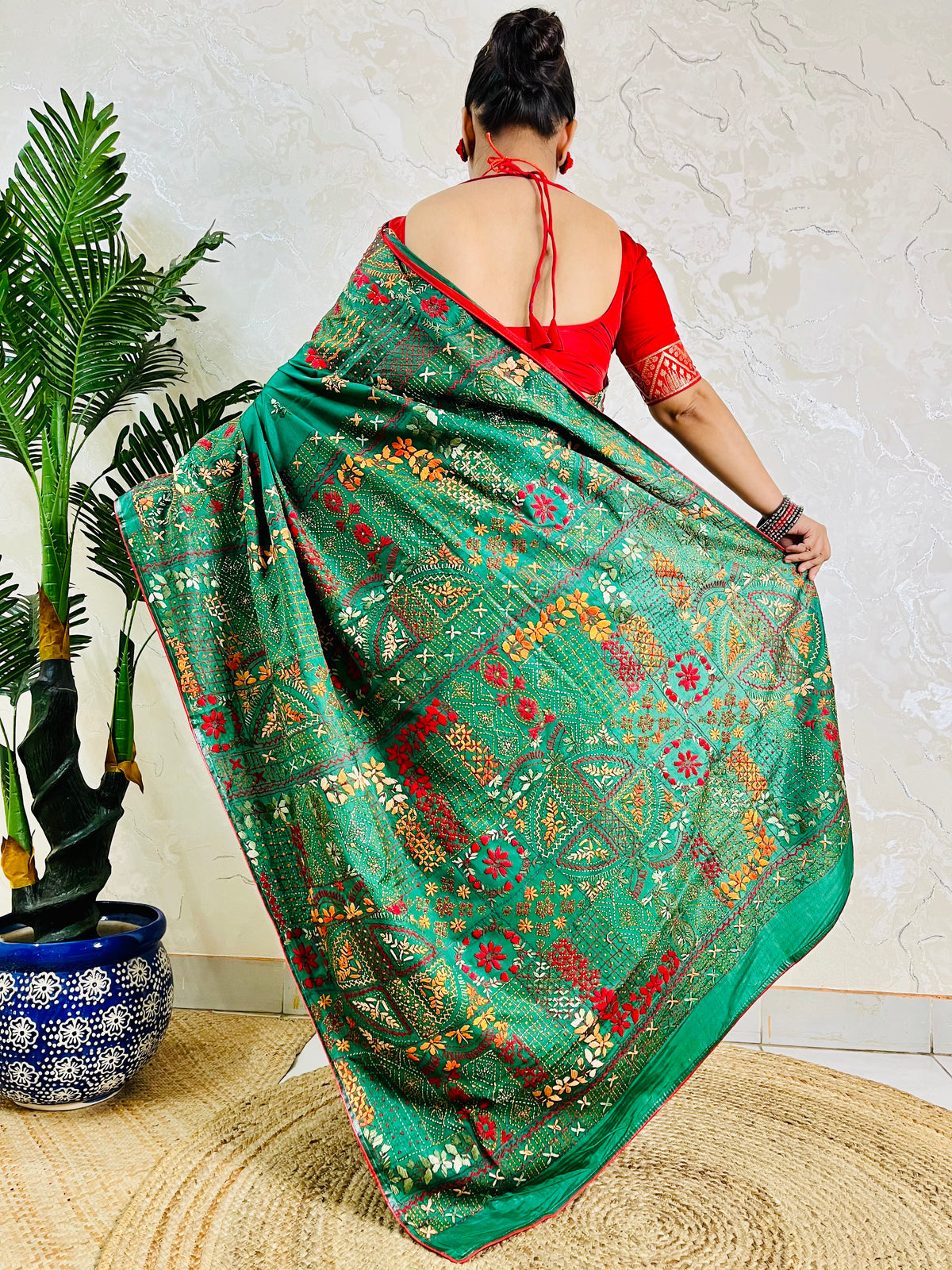Back standing view of emerald green Lambani saree, pallu draped over shoulder
