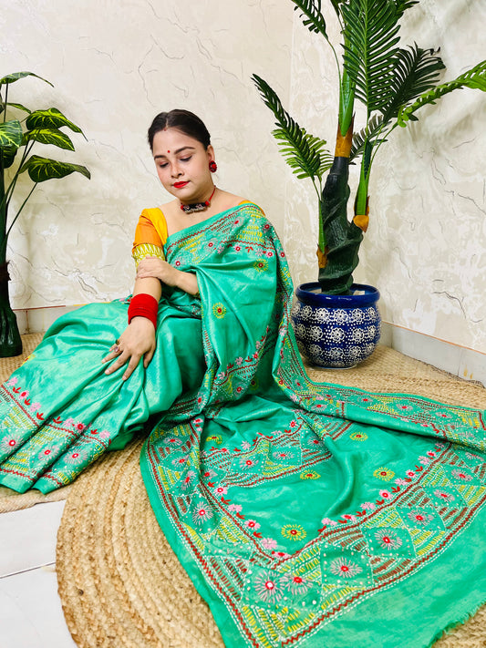 Woman wearing sea green tissue silk saree with traditional Lambani handwork