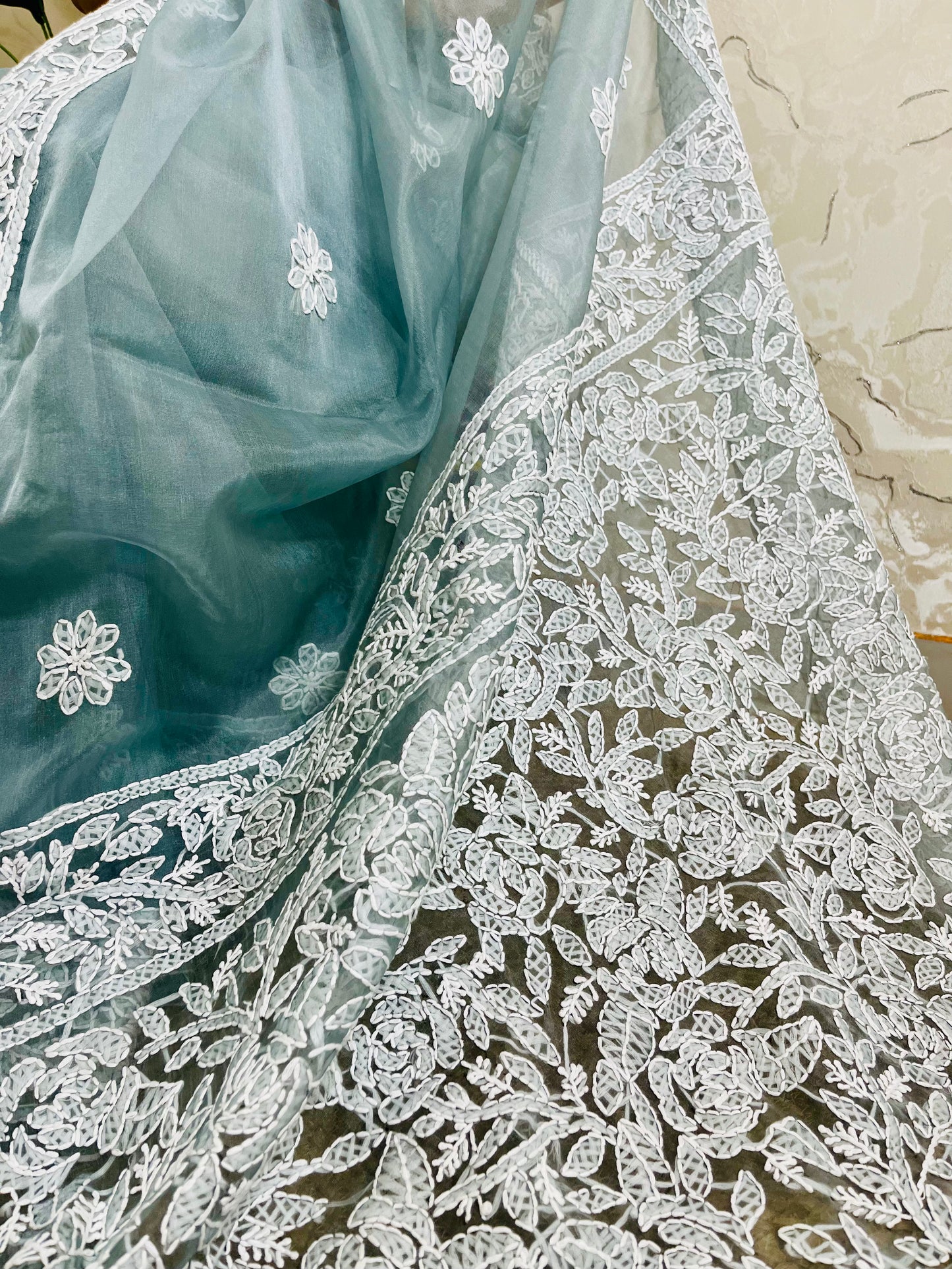 Close-up of structured white Lucknowi Chikankari jaal, vine, and shadow stitch hand embroidery on pastel dusty blue pure organza silk saree — Desi Aadat