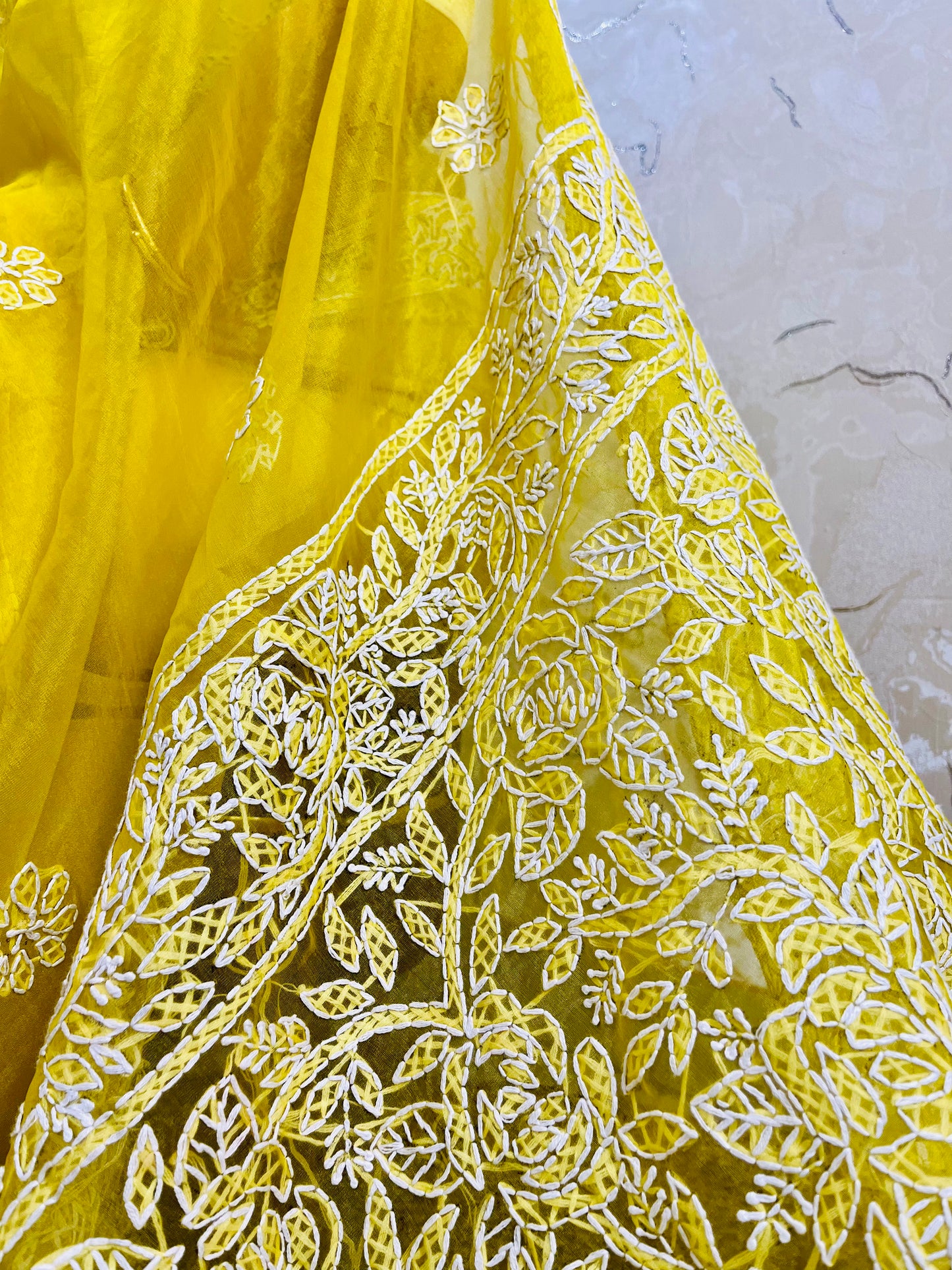 Close-up of dense white handmade Chikankari jaal and floral embroidery on pastel yellow pure organza silk saree — Desi Aadat