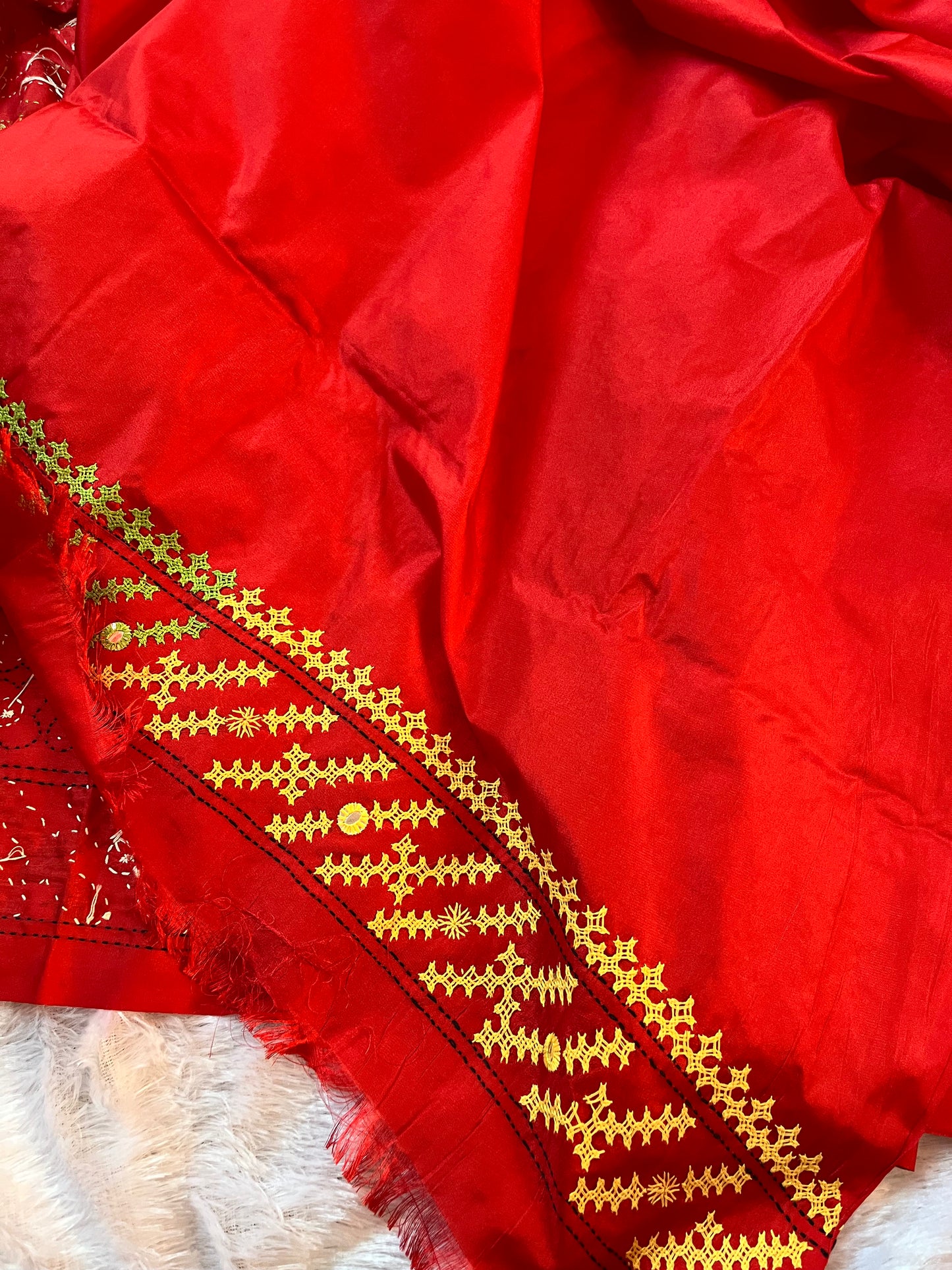 Matching red blouse piece with coordinating green yellow white Gujarati stitch details