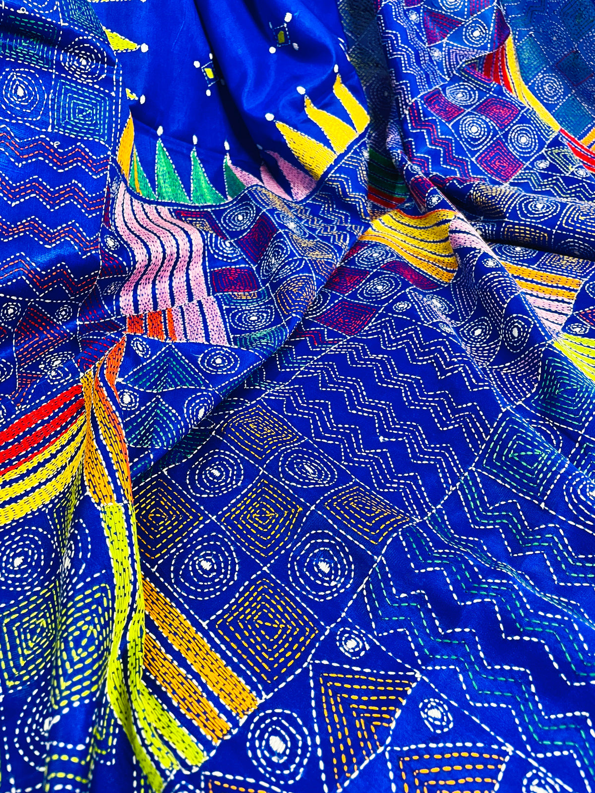 Close-up of Kantha patchwork embroidery in tonal blue on royal blue silk saree