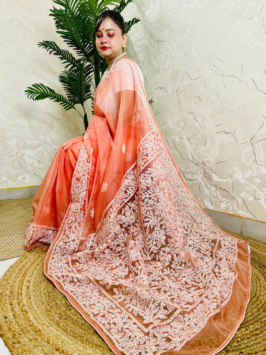 Handmade Lucknowi Chikankari pastel coral peach pure organza silk saree with tone-on-tone jaal and floral embroidery — side sitting drape view, Desi Aadat