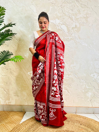 Front standing view of crimson red batik saree with white Kantha floral border and striped pallu