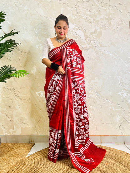 Standing pose showing crimson batik Kantha saree hem with white flower and leaf band
