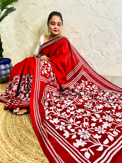 Side view of crimson red Kantha stitch saree pallu with framed flower garden and tassel motifs