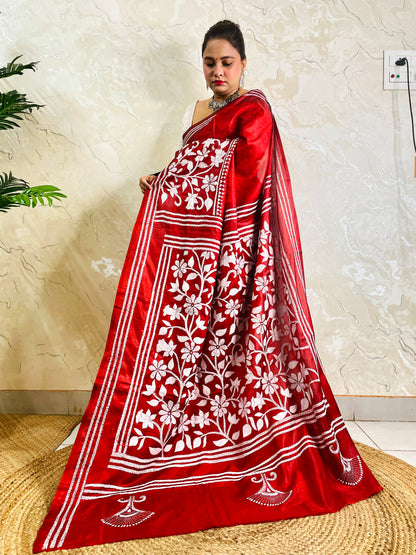 Front standing view of crimson red batik saree with white Kantha floral border and striped pallu