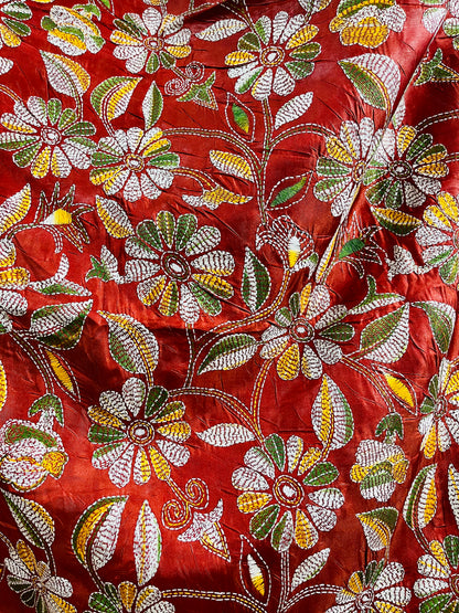 Close-up of rust red batik Kantha stitch silk with white, mustard and olive floral embroidery