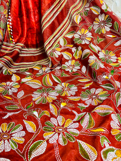Close-up of rust red batik Kantha stitch silk with white, mustard and olive floral embroidery