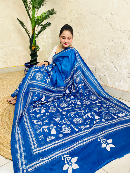 Seated pose in azure blue batik Nakshi Kantha saree with white peacock motifs on Bangalore silk