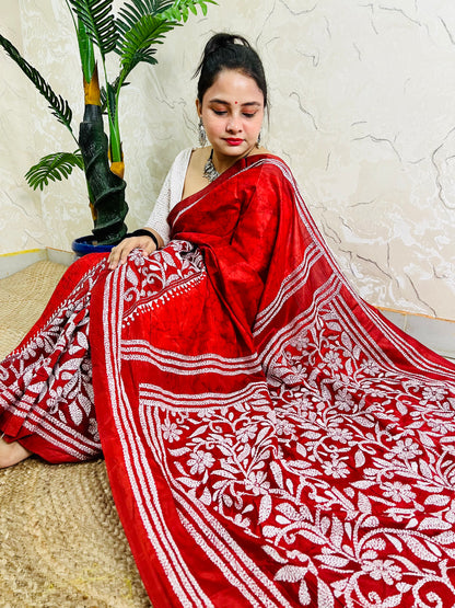 Seated pose in red batik Kantha saree with tree motif pallu on silk