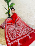 Seated pose in red batik Kantha saree with tree motif pallu on silk