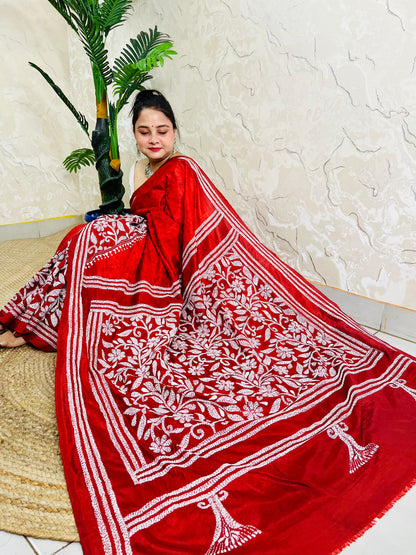 Seated pose in red batik Kantha saree with tree motif pallu on silk