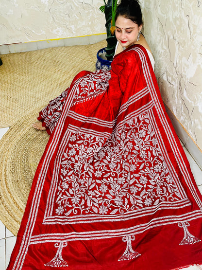 Seated pose in red batik Kantha saree with tree motif pallu on silk