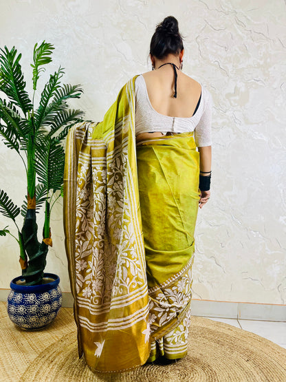 Back view of a woman modeling the exclusive handwoven olive green floral Katha stitch saree, highlighting the elaborate craftsmanship on the pallu