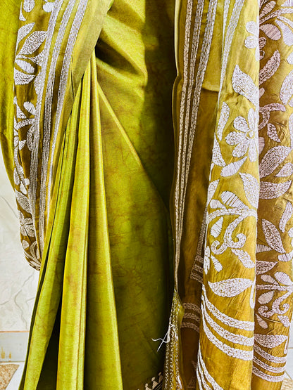 Close-up of the handcrafted white Katha stitch floral motifs and subtle batik dye texture on the olive green blended Bangalore silk saree