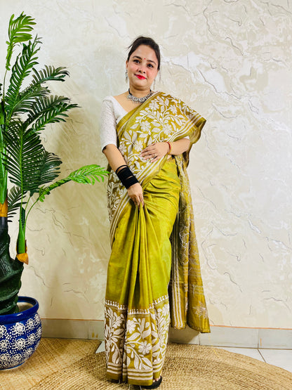 Full front view of a woman draped in the affordable luxury olive green Batik Katha silk saree showing the front pleats and pallu
