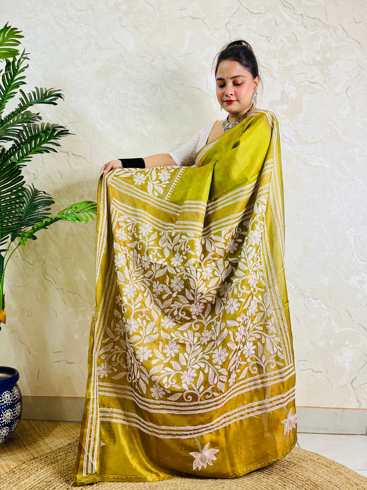 Woman wearing the handmade olive green Bangalore silk saree featuring traditional Batik Katha work and intricate border details