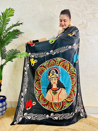 Pallu held open showing hand embroidered man's portrait in paisley mandala on black silk saree