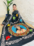 Front seated view of black Kantha saree with colourful face portrait and cream vine border