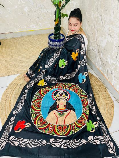 Side seated pose in black Kantha stitch saree with embroidered man's face portrait pallu on Bangalore silk