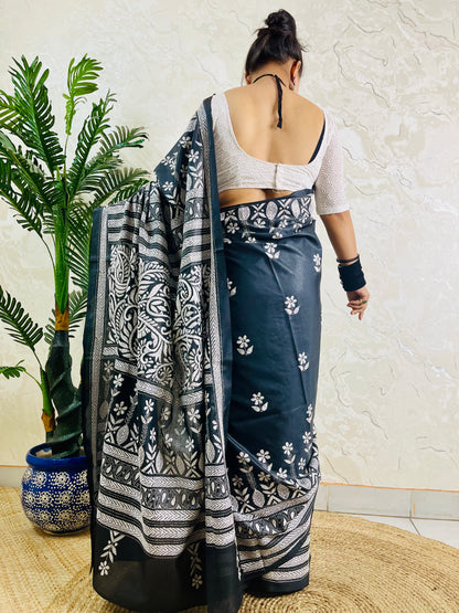 Back view of a woman draped in the black Katha stitch silk saree highlighting the grand, heavily embroidered paisley pallu