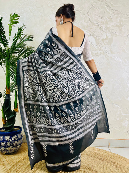 Back view of a woman draped in the black Katha stitch silk saree highlighting the grand, heavily embroidered paisley pallu