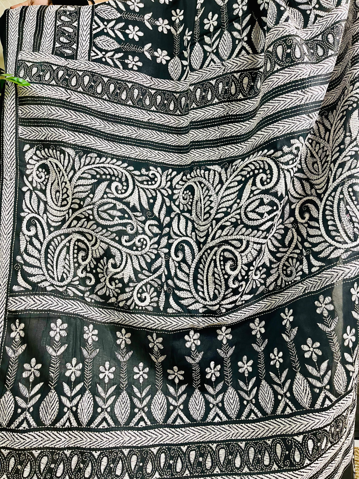 Detailed view of the multi-tiered white thread Katha embroidery on black Bangalore silk showing paisley and floral motifs