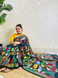 Woman seated in black multicolour Kantha stitch saree, front pallu spread view
