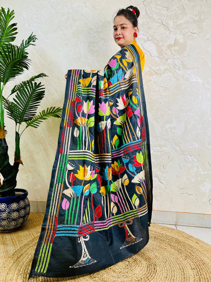 Woman holding open pallu of black Kantha saree showing striped lotus border