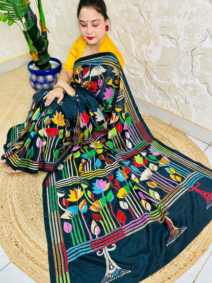 Woman seated in black Kantha lotus saree, side pallu draped view