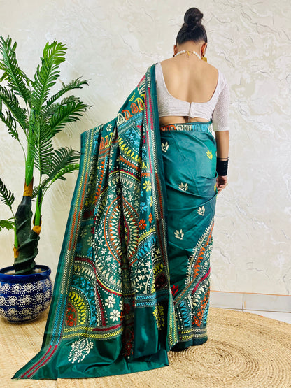 Rear view of a woman draped in the bottle green Kantha silk saree, showcasing the large circular multi-colored Mandala motif on the pallu.
