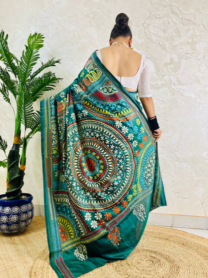 Rear view of a woman draped in the bottle green Kantha silk saree, showcasing the large circular multi-colored Mandala motif on the pallu.