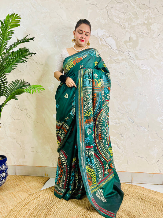 Model wearing the bottle green silk saree, showing the elegant drape of the embroidered pallu and subtle floral bootis on the pleats.
