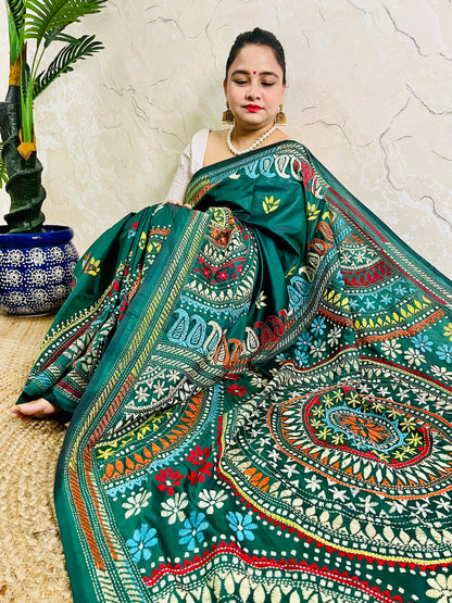 High-angle sitting pose displaying the spread-out hand-embroidered Mandala artwork and vibrant geometric thread work on deep bottle green silk.