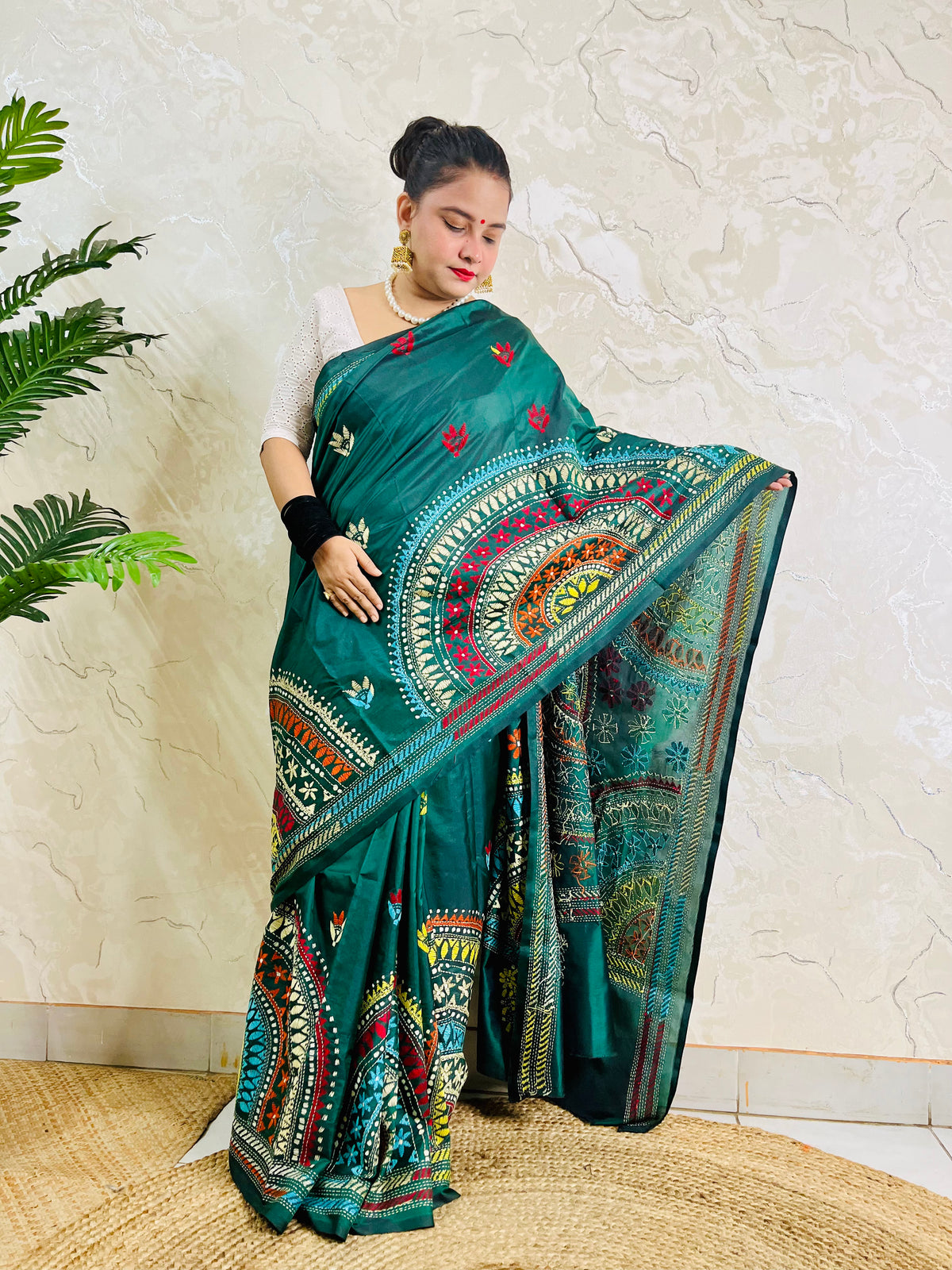 Model wearing the bottle green silk saree, showing the elegant drape of the embroidered pallu and subtle floral bootis on the pleats.