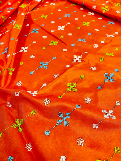 Close-up of orange Bangalore silk saree fabric showing Gujarati stitch motifs