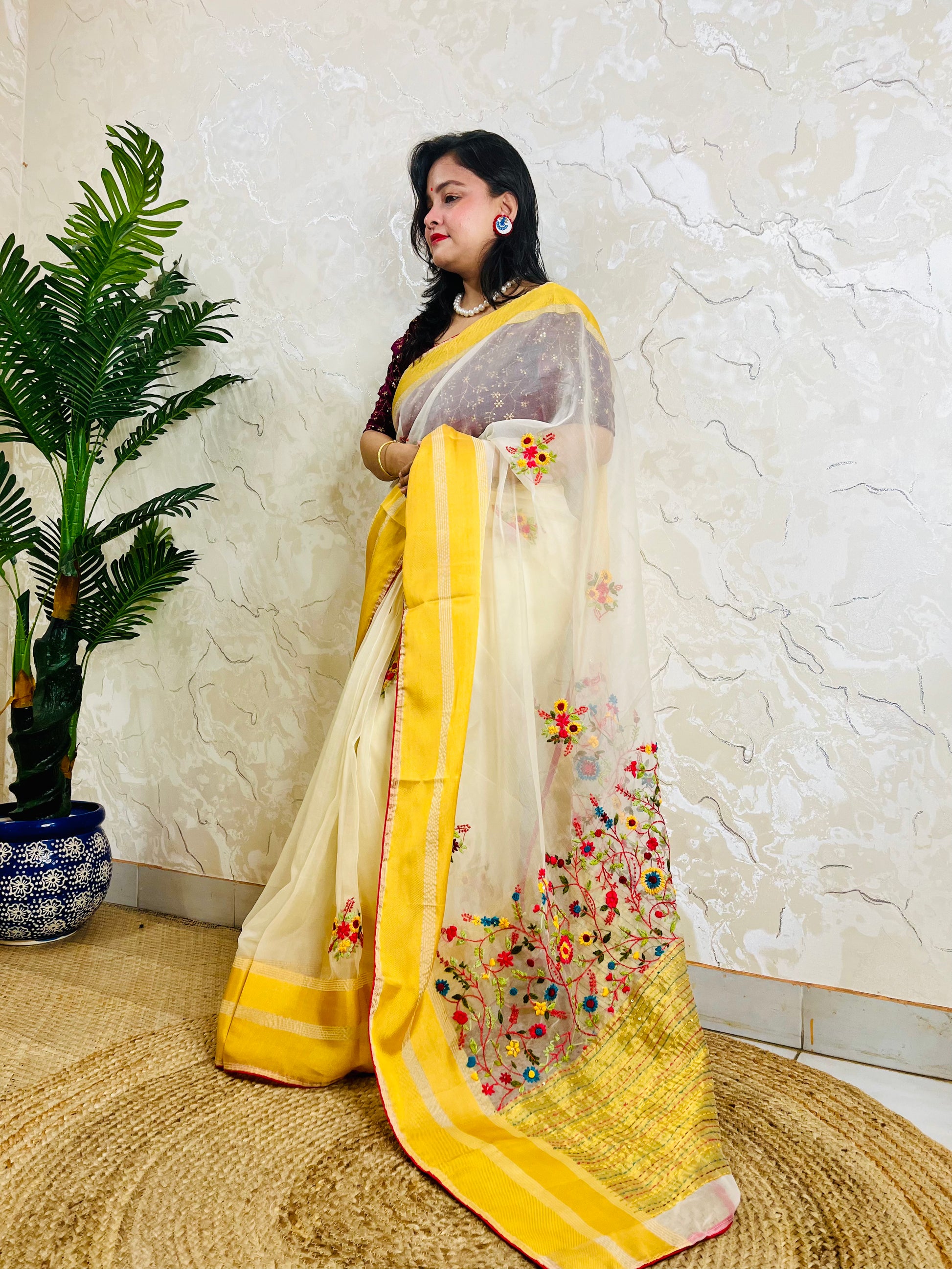 Handcrafted off white organza silk saree with multicolour Bullion Stitch floral embroidery and golden yellow woven border — side standing view, Desi Aadat