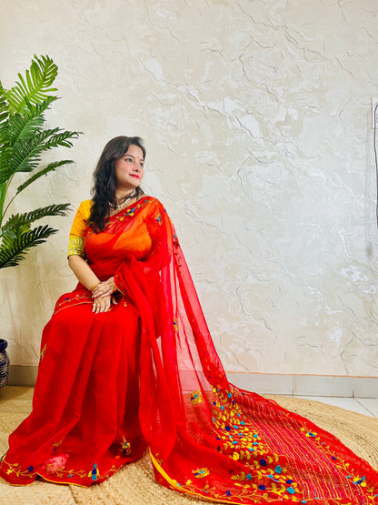 Handcrafted red organza silk saree with multicolour bullion stitch floral embroidery draped on model, side sitting view — Desi Aadat