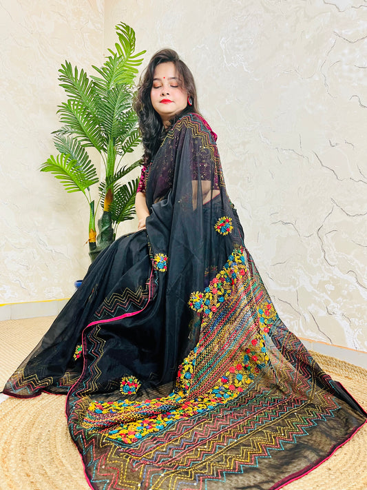 Woman sitting gracefully in handembroidered Black Organza Silk Saree with Bullion Stitch flowers and French knots — traditional saree look by Desi Aadat